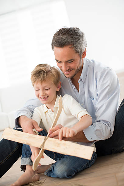 istock father and son building a wooden model plane 460889475