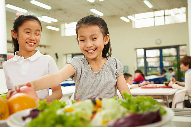 Student reaching for healthy food in school cafeteria stock photo