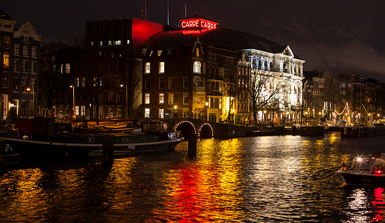 Amsterdam, The Netherlands - December 27, 2013: Illuminated facade and colourful reflections of the famous Neo-Renaissance theatre building \