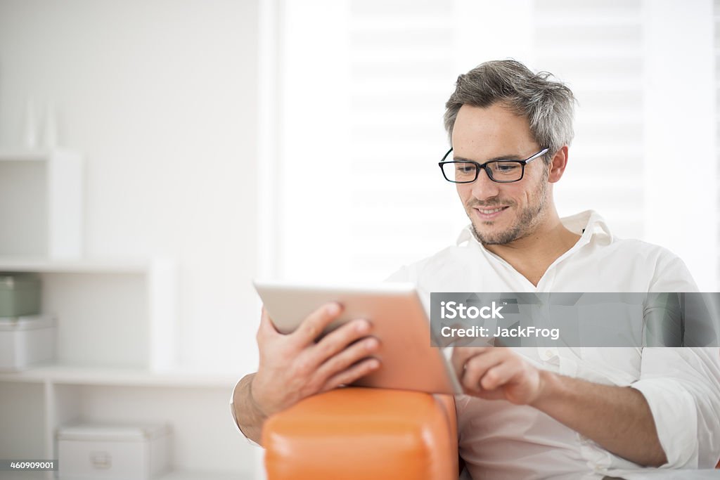 handsome man surfing on tablet handsome man surfing on tablet on a couch 30-34 Years Stock Photo