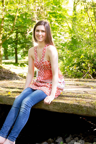 istock Happy brunette sitting on a wooden bridge 460913451