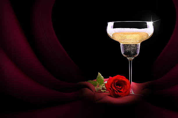 istock champagne glass on black and red silk with flower 460917289