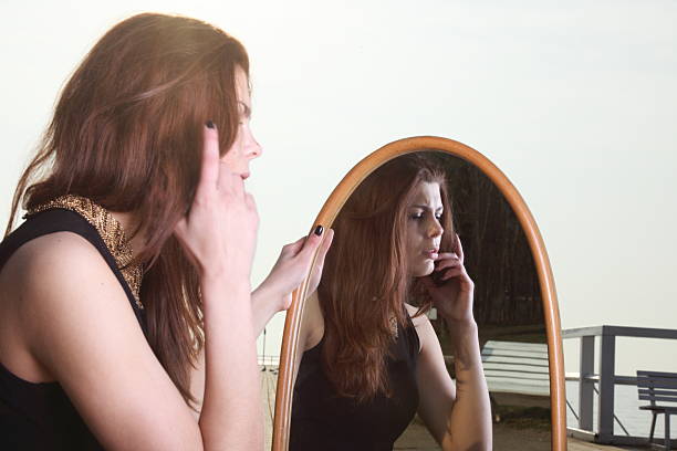 istock thoughtful woman looks at the reflection in mirror 460919271