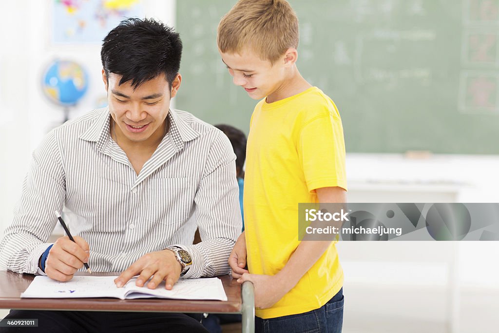 Giovane maschio insegnante scuola ragazzo di lavoro di gradazione - Foto stock royalty-free di Assegnazione di un voto