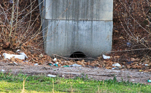 A water drainage site covered with litter