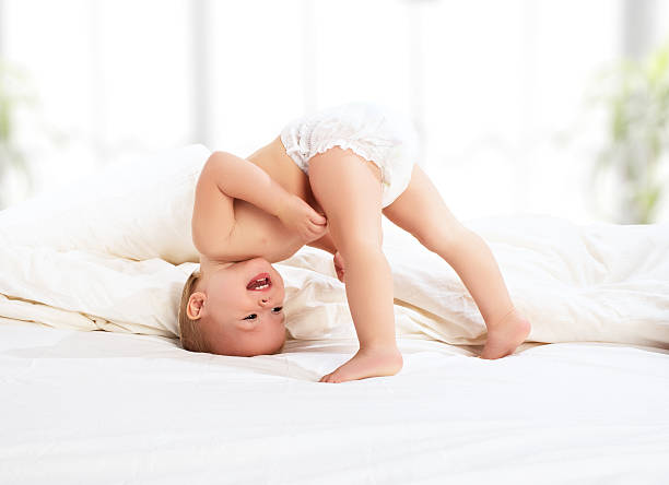 bebê criança feliz jogando na cama - baby cheerful child blanket - fotografias e filmes do acervo