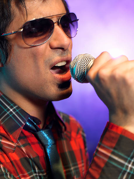 istock Closeup Of Young Man Singing Into Microphone 460930065