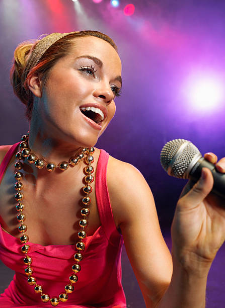 istock Closeup Of Young Woman Singing Into Microphone 460930213