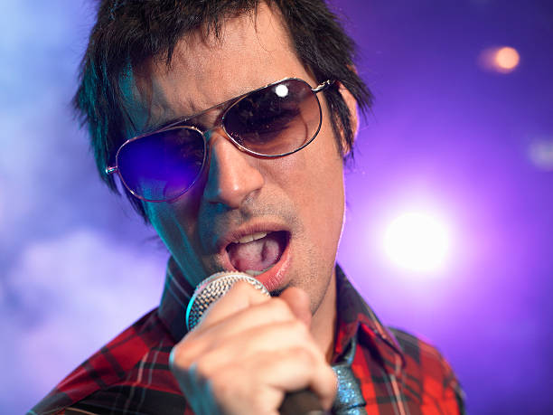 istock Closeup Of Young Man Singing Into Microphone 460930229
