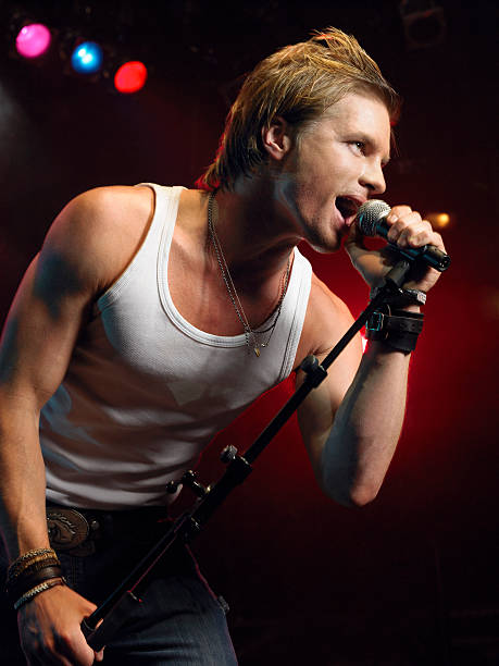 istock Closeup Of Young Man Singing Into Microphone 460930233