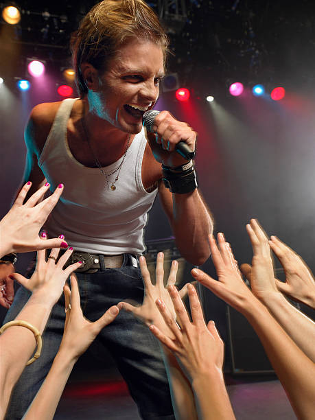 istock Man Singing Close To Adoring Fans 460930235