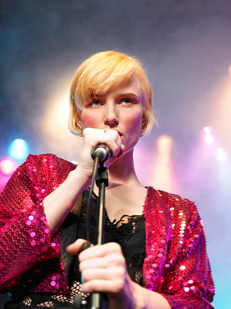 istock Closeup Of Young Woman Singing Into Microphone 460930247