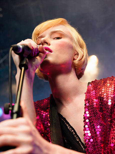 istock Closeup Of Young Woman Singing Into Microphone 460930331