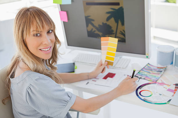 istock Blonde interior designer working at her desk 460930433