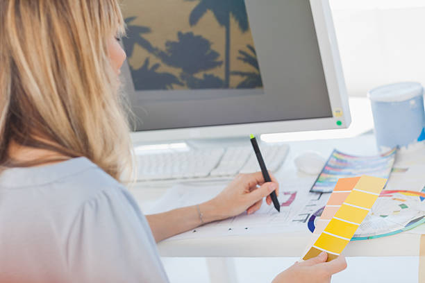 istock Blonde interior designer looking at colour charts 460930437