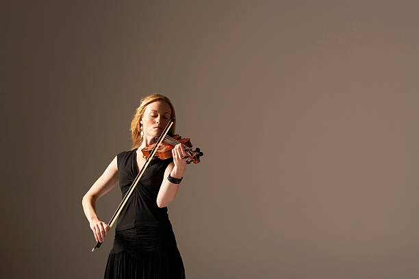 primer plano de mujer tocando violín - violinista fotografías e imágenes de stock