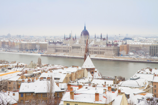 house of parliament over snowed roofs of Buda hill, Budapest, Hungary