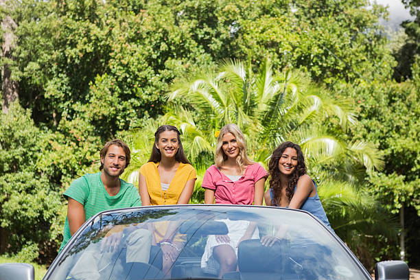 istock Four young attractive friends sitting in a convertible 460957663