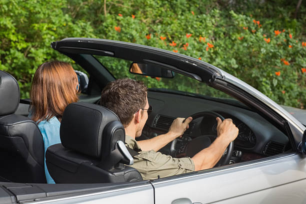 istock Happy young couple sitting in convertible 460969673