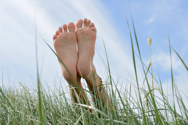 Barefoot on the sand dune under light blue sky stock photo