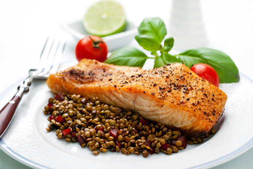Roasted salmon steak served on plate with cooked lentil for side dish