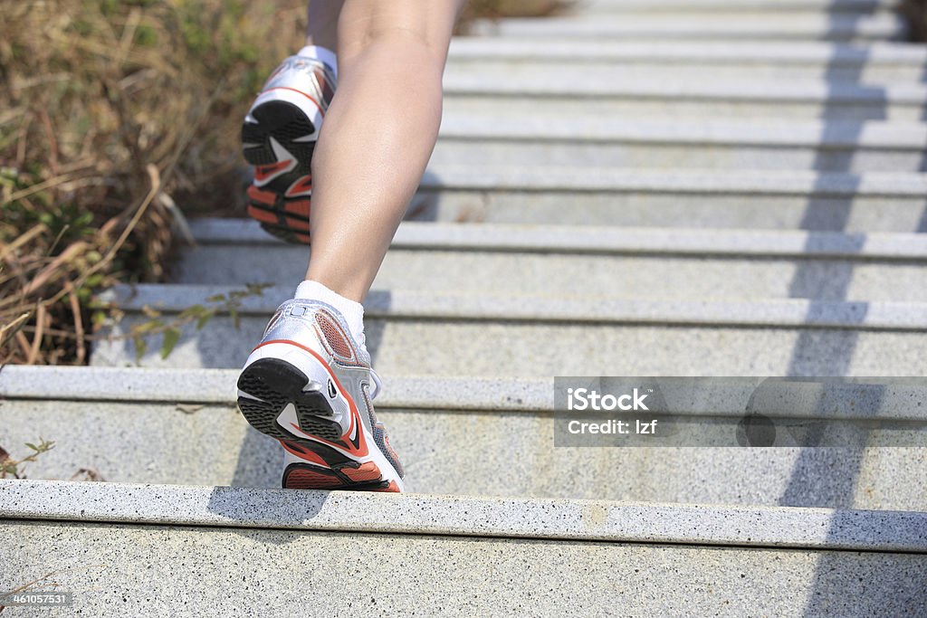 woman running up on mountain stairs back of healthy woman legs running up on mountain stairs to peak Active Lifestyle Stock Photo
