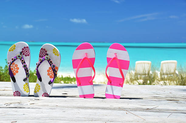 istock Two pairs of flip-flops against ocean 461057745