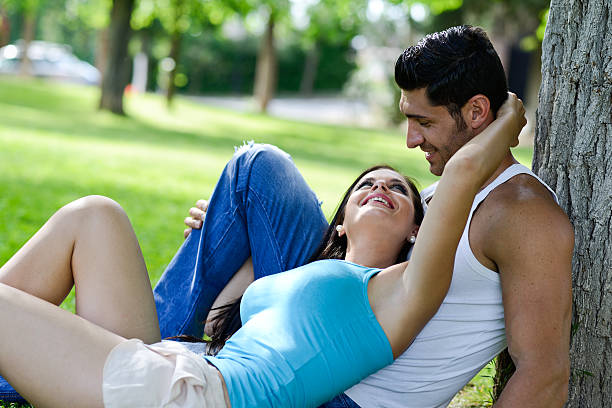 istock Happy smiling couple laying on green grass 461058755