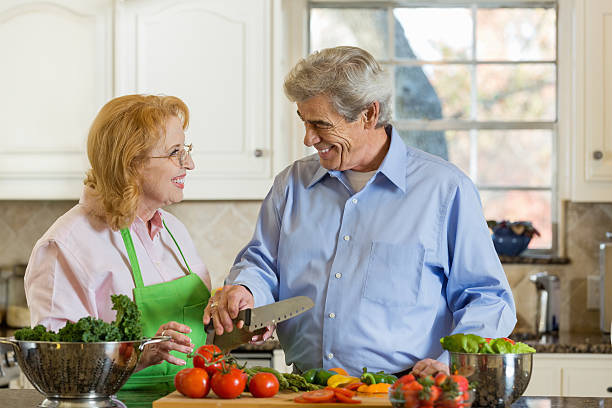 istock Senior married couple preparing meal together at home in kitchen 461060451