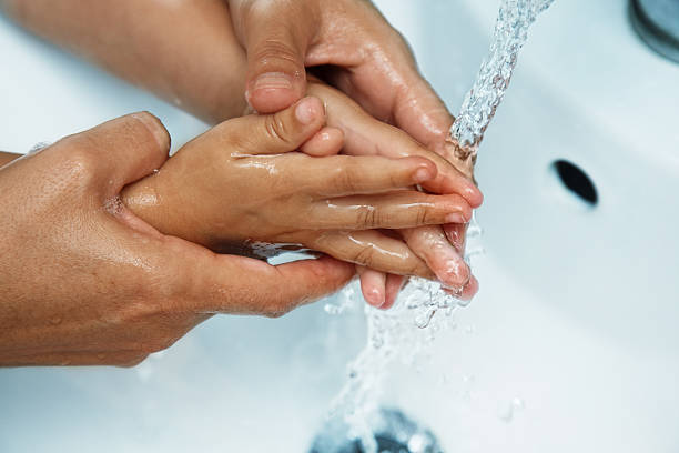istock mother washing her children hands 461066077