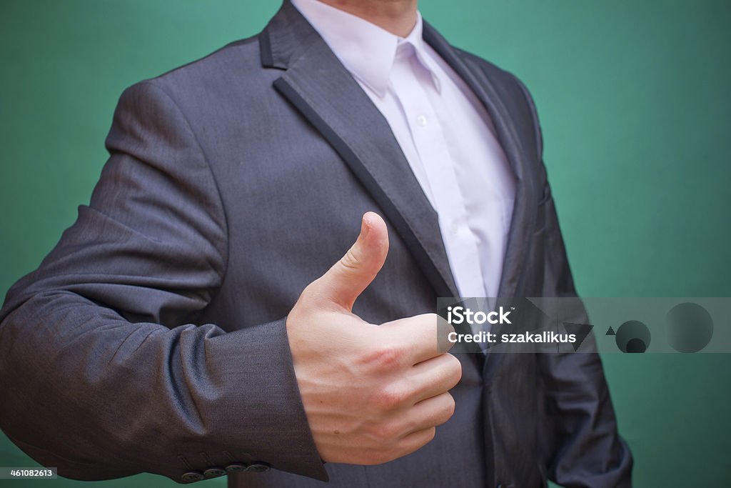 Businessman in studio with thumb up Businessman showing thumb up Adult Stock Photo