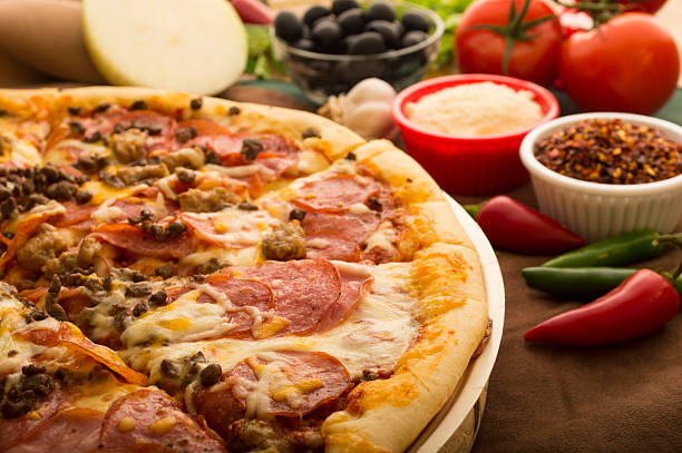 istock A fresh hot pizza with vegetables in the background 461082707