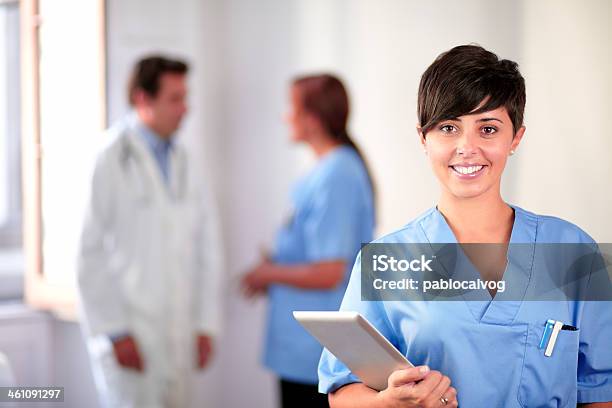 Lovely Latin Nurse On Blue Uniform Standing Stock Photo - Download Image Now - Adult, Backgrounds, Beautiful People