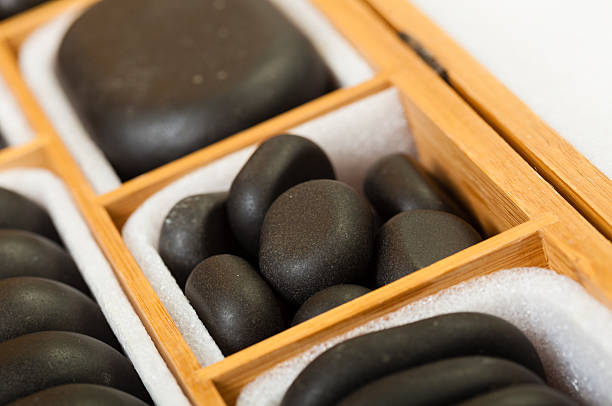 Beauty salon. Close up of black spa zen massage stones in wooden case with white blank copy space for text message. Relax concept.