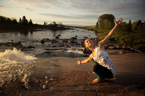 Female Yogi Doing Sunrise Salutation stock photo