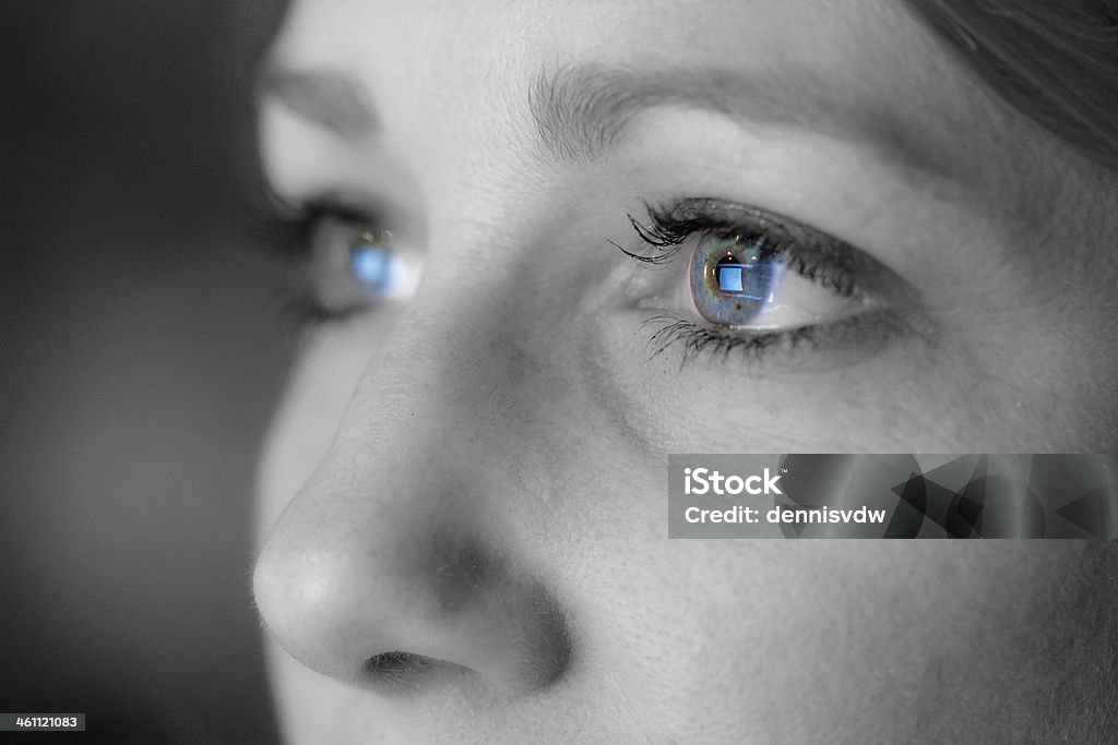 Blue eyes Close up portrait of a beautiful woman working on the computer, reflected in her eyes Eye Stock Photo