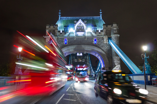 The start of Tower Bridge in London with red buses and a black taxi