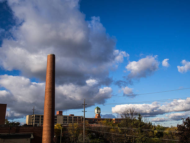 istock smokestack bricks buildings clock faces clouds blue sky wires trees 461122051