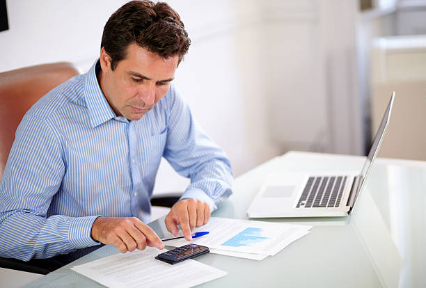 istock Hispanic employee working with his calculator 461125839