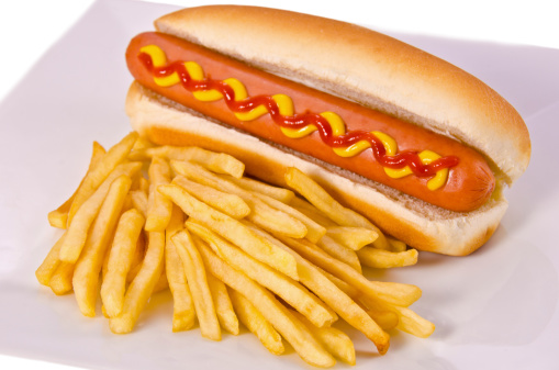 Typical Latin America Salchipapa. Sausages with fries, ketchup, mustard and mayo, isolated on white background