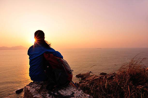 istock woman hiker sit on rock face the sunrise 461152157