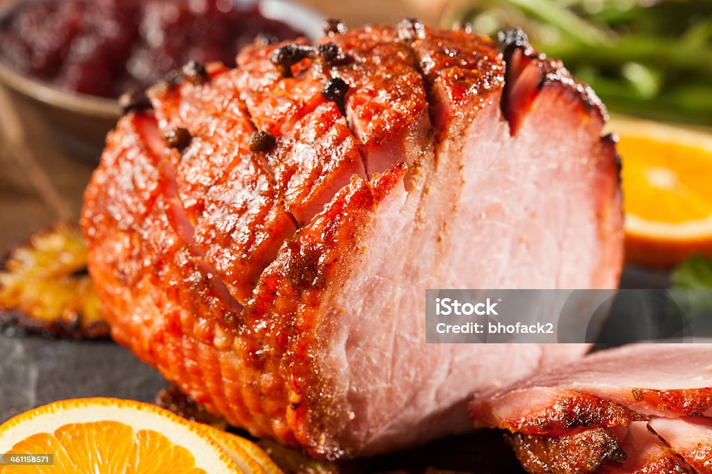 Orange honey glazed ham with orange slices Traditional Sliced Honey Glazed Ham Ready for the Holidays Ham Stock Photo