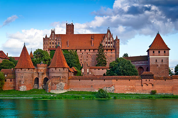 Medieval Malbork castle on the river Nogat Malbork, Poland - August 10, 2011:Medieval Malbork castle on the river Nogat, Poland. The largest castle in the world by surface area, and the largest brick building in Europe. Historical capitol of the Teutonic Order - Crusaders malbork photos stock pictures, royalty-free photos & images