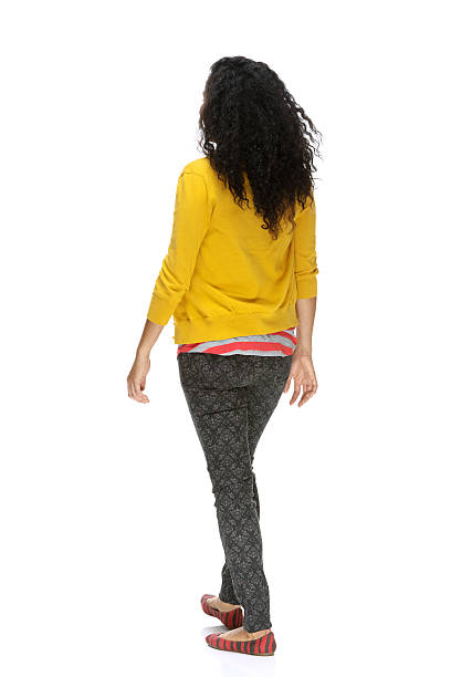 Rear view of woman walking with cardigan stock photo