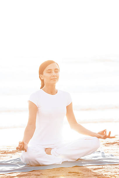 istock Woman Doing Yoga on Beach 461165125