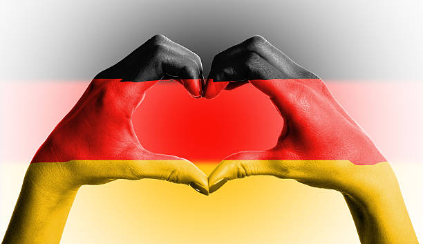 istock German flag over heart-shaped human hands on isolated background 461170763