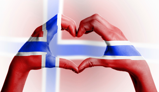 Norwegian flag over the female heart-shaped hands