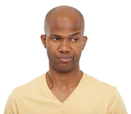 Studio shot of a young African-American man looking to the side and smirking