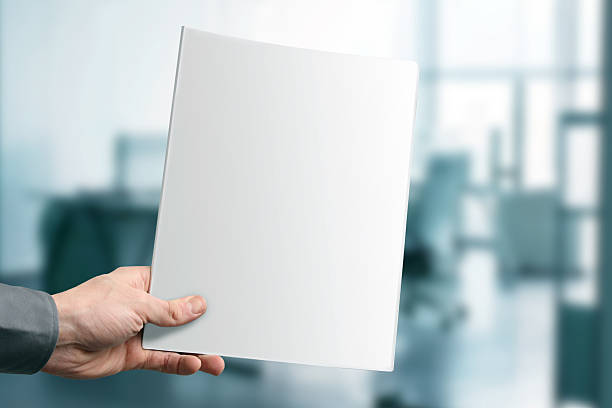 istock hand holding white blank magazine cover 461213091