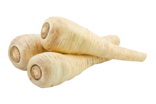 Three raw parsnips isolated on white background. This is a macro shot with large depth of field (DOF). 